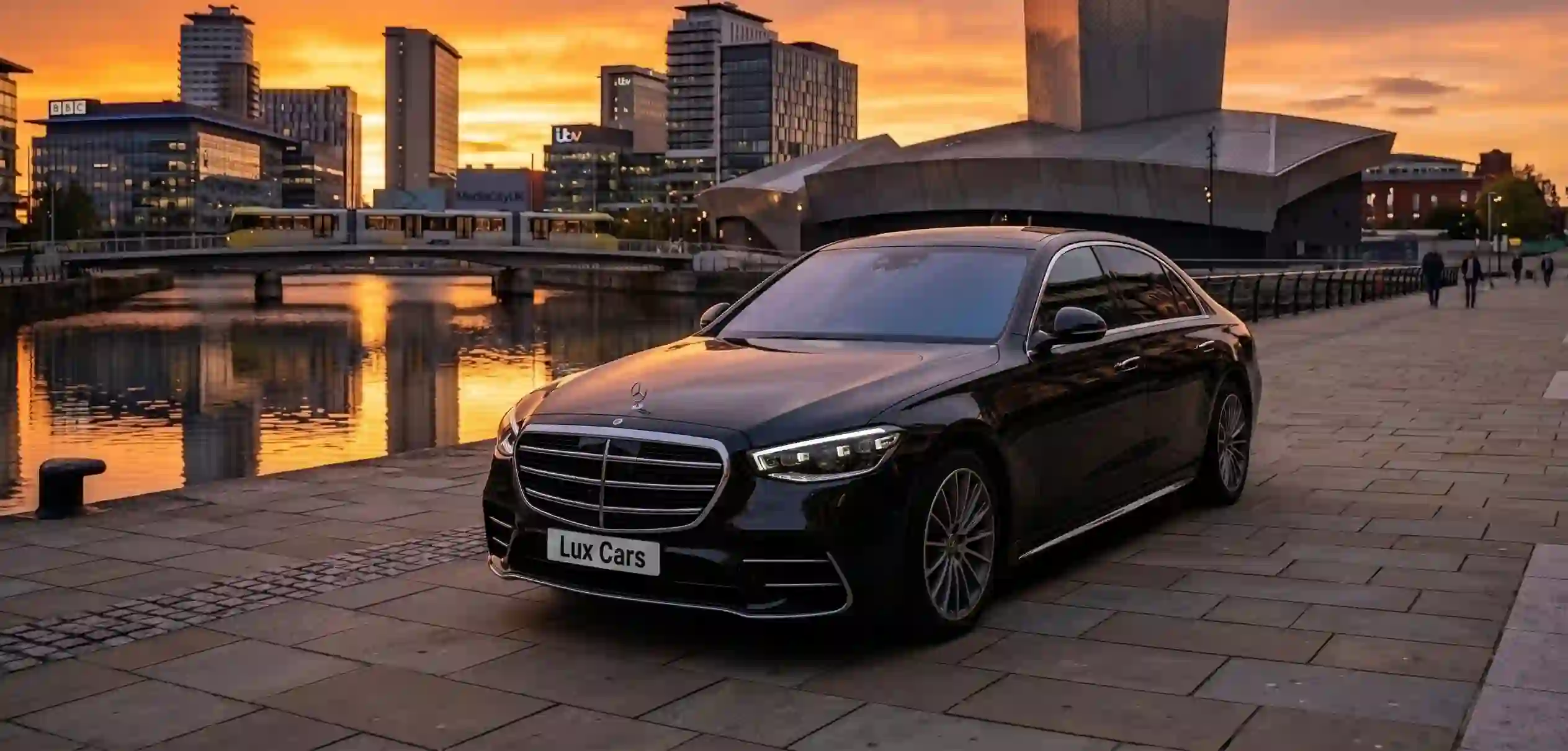 A prestigious black Mercedes S-Class sedan positioned for an executive transfer, representing the flagship VIP chauffeur service offered by Lux Cars across the UK.